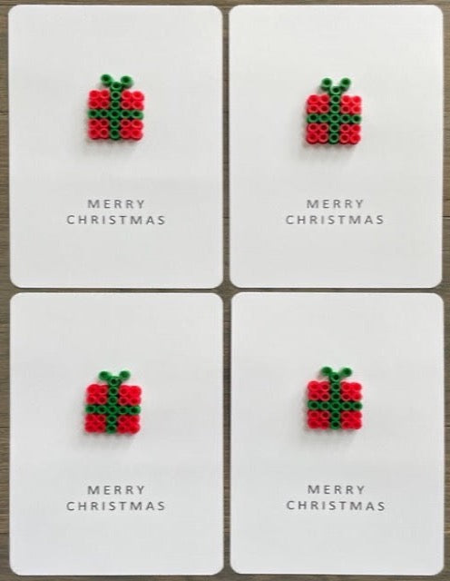Picture of a set of 4 Merry Christmas cards that each have a red with green ribbon gift box on them