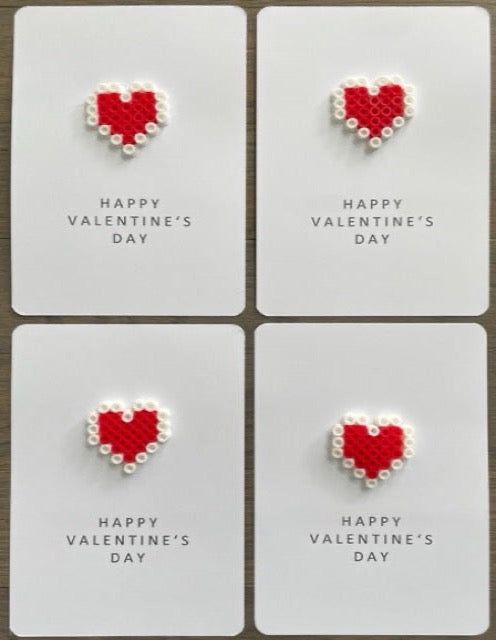 Picture of a set of 4 Happy Valentine's Day cards that each have a red and white heart on them