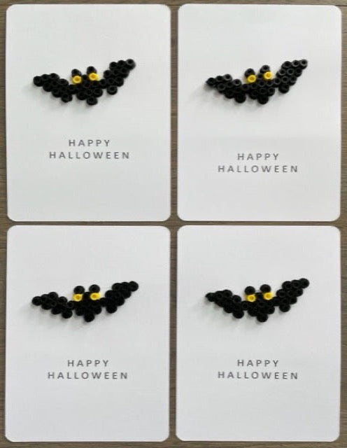 Picture of a set of 4 Happy Halloween cards that have a black bat with yellow eyes on them