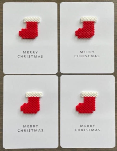Picture of a set of 4 Merry Christmas cards that have red and white stockings on them