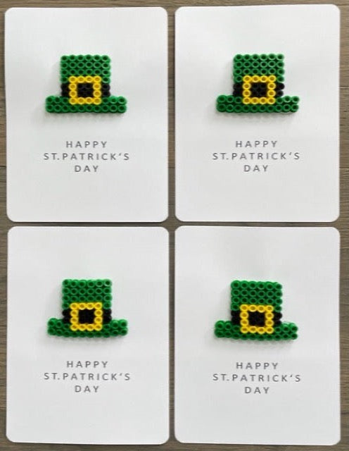 Picture of a set of 4 Happy St. Patrick's Day Cards that each have a green hat with a yellow buckle on them