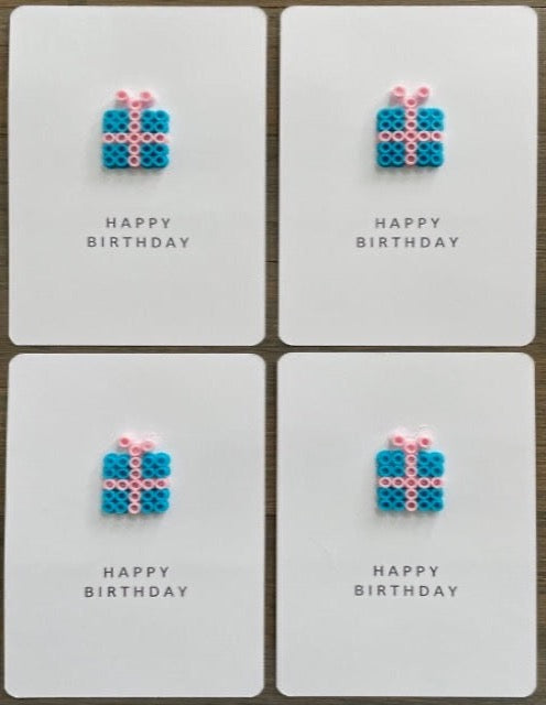 Picture of a set of 4 Happy Birthday cards that have a blue gift with pink ribbon on each.