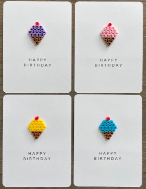 Picture of a set of 4 ice cream cone Happy Birthday cards.  One card is a purple ice cream cone, one card is a pink ice cream cone, one card is a yellow ice cream one, and one card is a blue ice cream cone