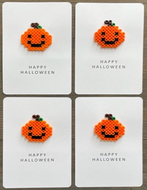 Picture of a set of 4 Happy Halloween cards that each have an orange pumpkin on it. The pumpkin have a black smily face