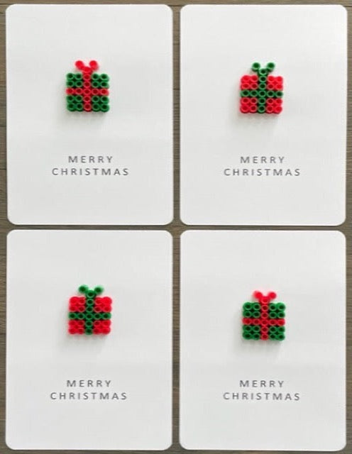 Picture of a set of 4 Merry Christmas cards. 2 cards have dark green gifts with red ribbon and 2 cards have red gifts with green ribbon 