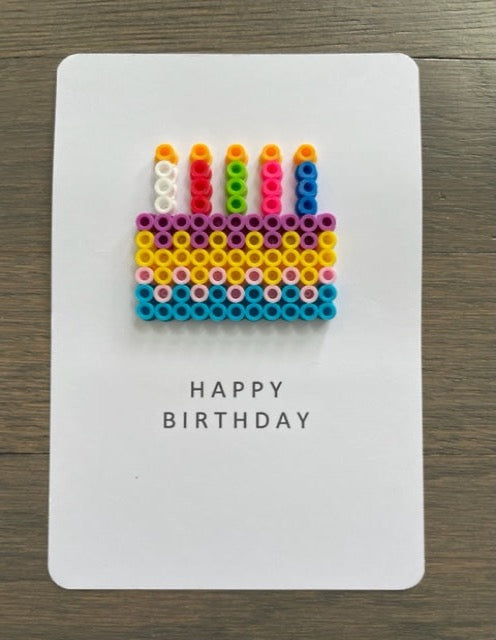 Picture of a Multi-colored birthday cake with 5 candles on  the Happy Birthday card