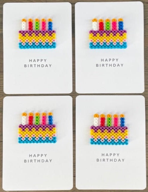 Picture of a set of 4 Happy Birthday cards that have a multi-colored cake with 5 candles on each card