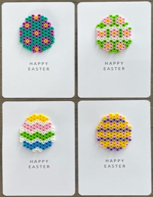 Picture of a set of 4 Happy Easter eggs. One is teal, purple, and yellow, one is lime green, pink, yellow, and white, one is yellow, pink, lime green, yellow, blue, and white, and one is yellow, purple, and pink