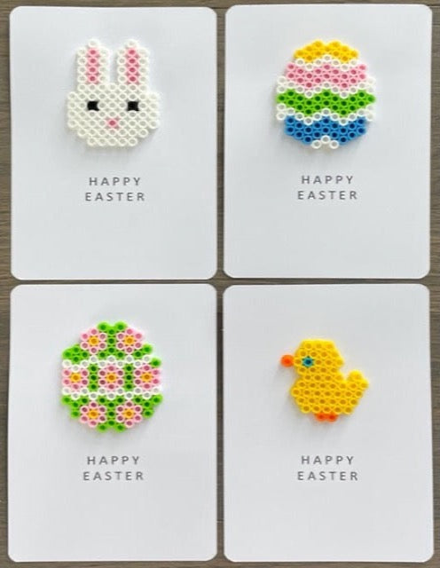 Picture of a set of 4 Happy Easter cards. One card is a white bunny with pink accent ears, one is a yellow, pink, lime green, blue, and white Easter egg, one is a lime green egg with pink, yellow, and white, and one is a yellow chick.