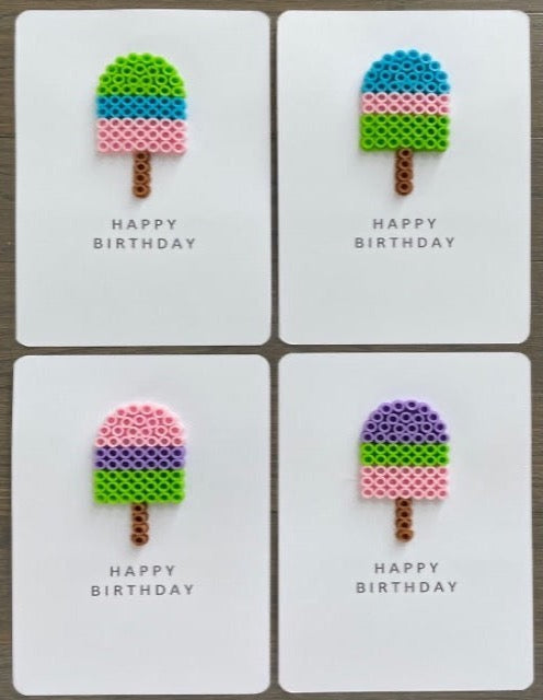 Picture of a set of 4 popsicle Happy Birthday cards. One is lime green, blue and pink, one is blue, pink, and lime green, one is pink, purple, and lime green, one is purple, lime green, and pink