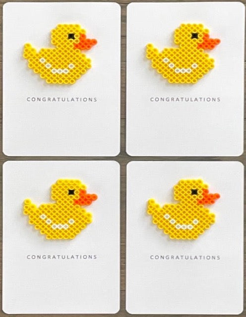 Picture of a set of 4 congratulations cards that each have a yellow duck on them