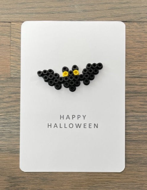 Picture of a Happy Halloween card that has a black back with yellow eyes on it