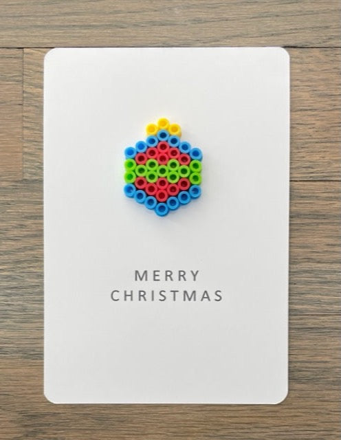 Picture of a Merry Christmas card with a blue, red, lime green ornament on it