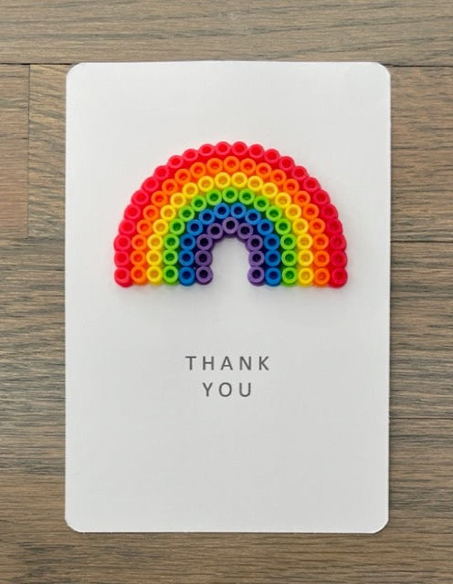 Picture of a Thank You card with a large rainbow on it.  Rainbow is red, orange, yellow, lime green, blue, and purple