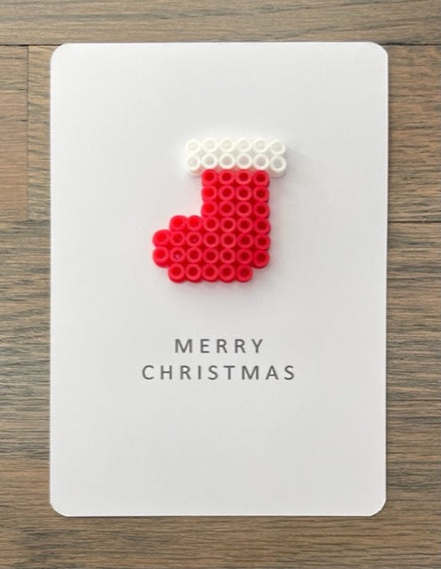 Picture of a Merry Christmas card with a red and white stocking on it