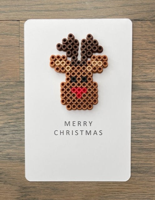 Picture of a Merry Christmas card that has a light brown with dark brown antlers on it