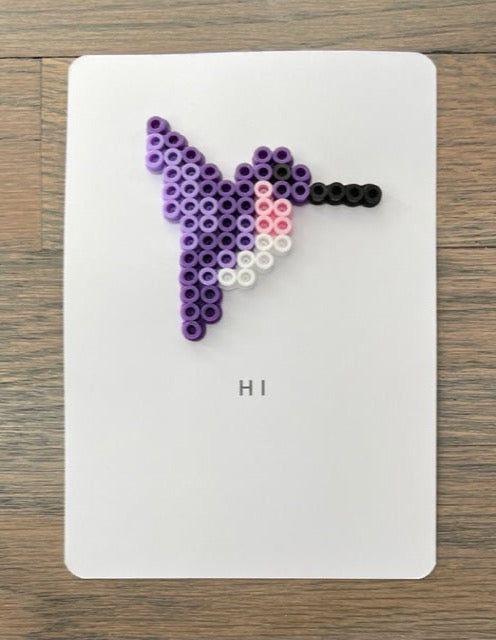 Picture of a Hi card with a purple, pink, and white hummingbird on it