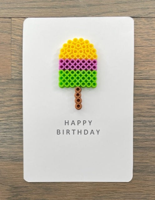 Picture of a Happy Birthday card that has a yellow, purple, lime green popsicle on it