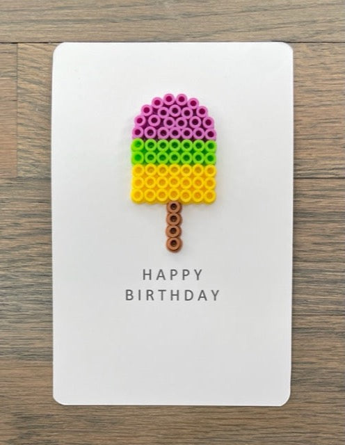 Picture of a Happy Birthday card with a purple, lime green, and yellow popsicle on it