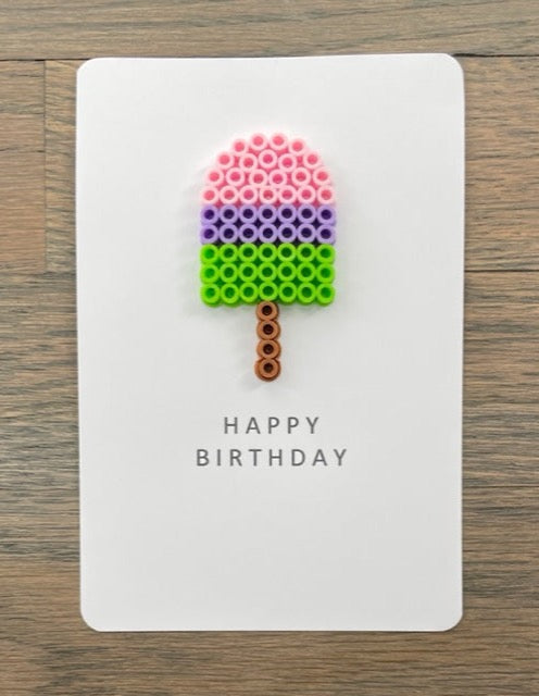 Picture of a Happy Birthday card with a pink, purple, and lime green popsicle on it