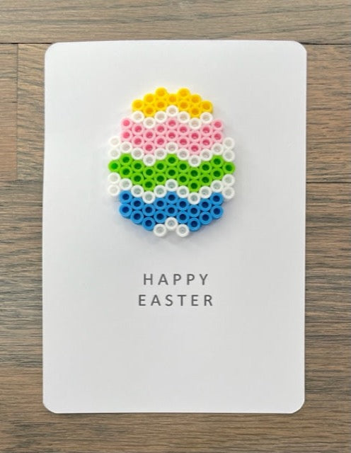 Picture of a Happy Easter card with a yellow, pink, lime green, blue, white Easter egg on it 