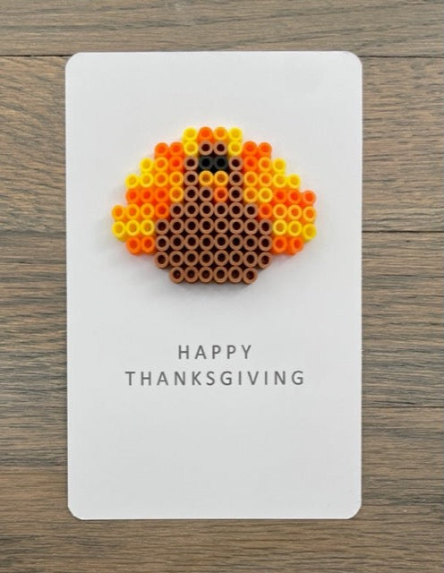 Picture of a Happy Thanksgiving card with a light brown, orange, yellow turkey on it