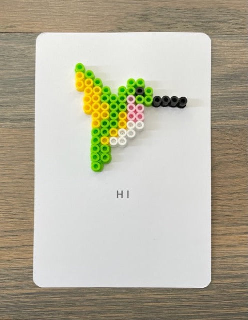 Picture of card to say Hi that has a lime green, yellow, pink, and white hummingbird on it
