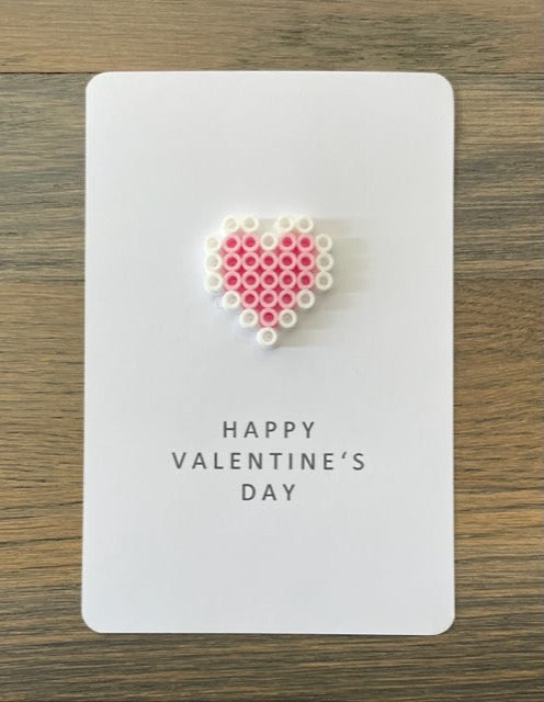 Picture of a Happy Valentine's Day card with a  pink and white heart on it