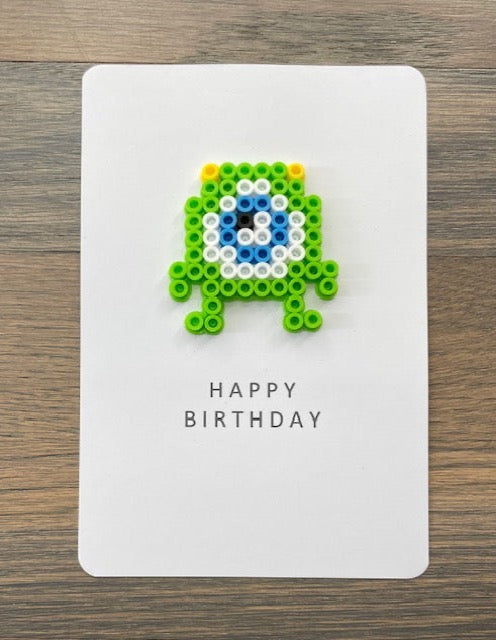 Picture of a Happy Birthday card that has a lime green, blue, and white monster on it