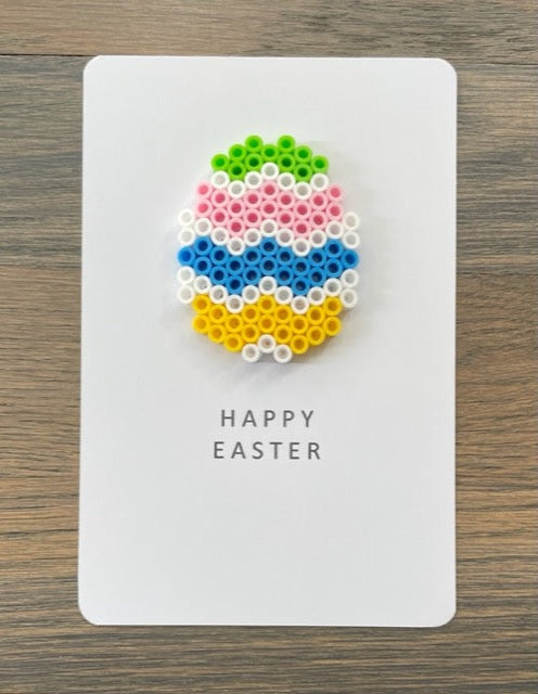 Picture of a Happy Easter card with a lime green, pink, blue, yellow and white Easter egg on it