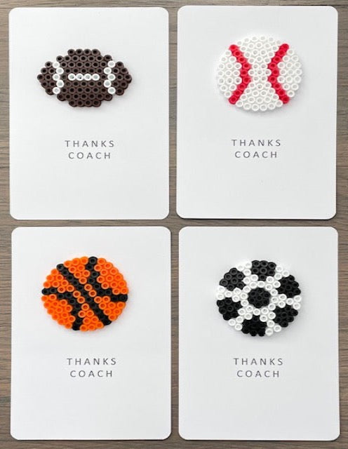 Picture of a set of 4 ball cards that say Thanks Coach.  One card has a football on it, one card has a baseball on it, one card has a basketball on it, one card has a soccer ball on it