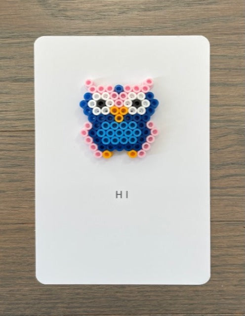 Picture of a card to say hi.  Card has a pink, dark blue, and light blue owl on it