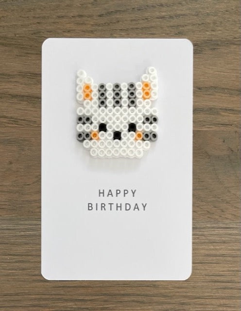 Picture of white and grey cat face on a Happy Birthday card.