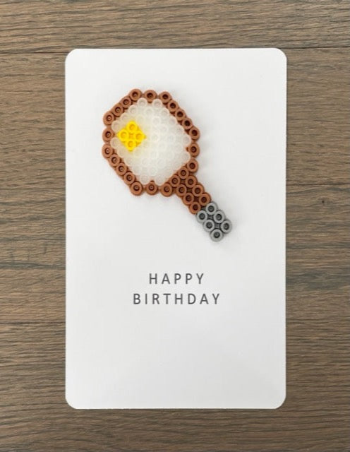 Picture of a Happy Birthday card with a tennis racket and ball on it.