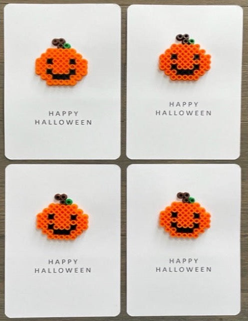 Picture of a set of 4 Happy Halloween cards that each have an orange pumpkin on it. The pumpkin have a black smily face