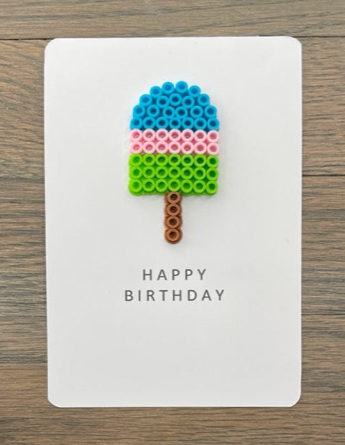 Picture of a Happy Birthday card with a blue, pink, lime green popsicle on it